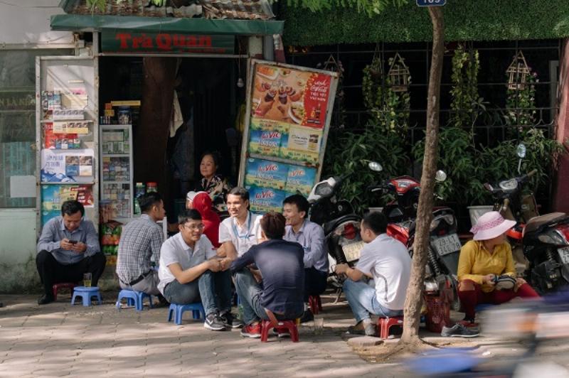 Một người bán hàng đang chuẩn bị đồ ăn tại quán ăn đêm Hà Nội, khung cảnh quen thuộc trên vỉa hè.